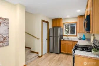 Convenient Half-Bath located off the Kitchen through the White Door next to the Fridge.