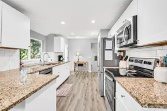 Gorgeous updated kitchen with granite counters, undermount kitchen sink, full height tile backsplash, stainless steel appliances & lots of cabinets