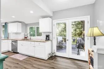 French doors lead out onto the deck & overlook the trees. It also lends more natural light to the kitchen