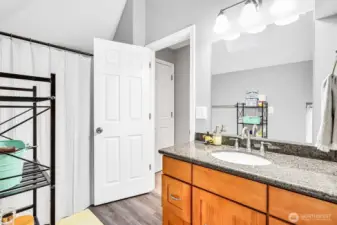 Bathtub/shower with tile surround.  Vaulted ceiling even in the bathroom
