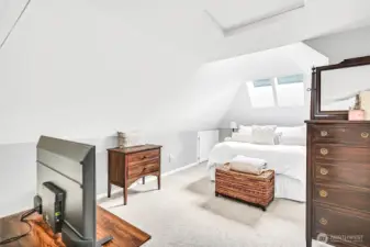 The primary bedroom, with 2 walk-in closets, en suite bath, extra storage & stylish ceilings, oozes charm.