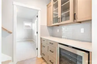 Wine/beverage fridge. Stairway to the left. Primary straight ahead.