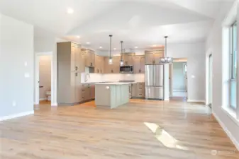 Great room looking into the kitchen. Cabinetry is rift-cut white oak and quartz countertops.