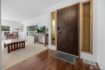 Heavy duty front door with 2 locks.  A keyed handle lock and also a keypad deadbolt.  The living room with plush newer carpet and bright color. An abundance of windows for good natural light.