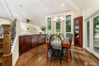 Dining room with built-in buffet, lighted corner cabinets with glass shelves. French doors to deck with built-in BBQ, sink, granite counter