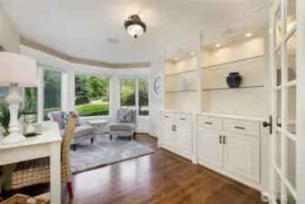 Office with bay window and built-in lighted cabinets. Lower cabinet access to oversized crawl space (another room?)