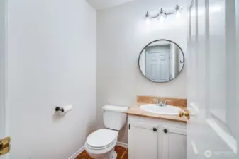 Conveniently located on the main floor, the guest powder room (half bath) features a modern vanity and toilet, perfect for visitors.