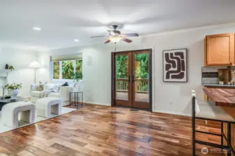 Large windows and a glass door connect the comfortable family room directly to the beautiful deck. This view emphasizes the seamless indoor-outdoor living and the privacy of the half-acre backyard.