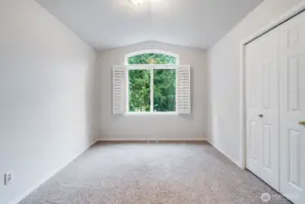This bright secondary bedroom is situated near the front of the home on the upper level. It offers ample closet space and generous natural light, making it a perfect guest room or child's bedroom.