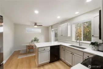 Virtually Staged. Beautifully updated kitchen showcasing new quartzite counters for timeless durability, refreshed cabinetry, modern appliances, and an eat-in bar ideal for entertaining or everyday dining.