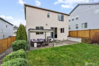 Backyard patio has room for seating, comes with a retractable awning, and is plumbed for a gas bbq