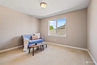 2nd bedroom on top floor staged as sitting area. Would easily fit a queen sized bed.