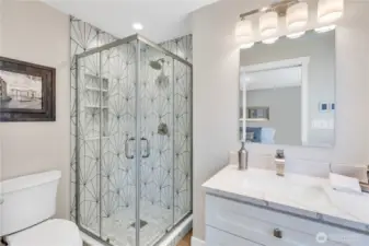 Designer tiled shower with niches for bath products. Quartz counters on slow-close cabinet drawers, decorator faucet.  Heated floors are a treat on chilly mornings!