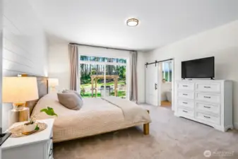 Primary bedroom with custom door leading right to the salt water hot tub. Great sized, modern look
