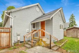 Side yard with fence and Unit 2 directly behind with alley access.