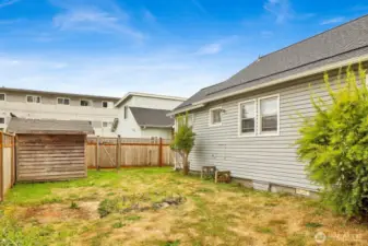 Side yard with fence and Unit 2 directly behind with alley access.