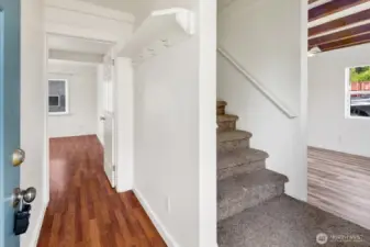 Covered entry with stairs leading to second floor, office to the left, and down the hall to 1st bedroom with no closet, or second living area.