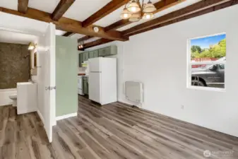 Living room view with kitchen to the right and bathroom/laundry to the left.