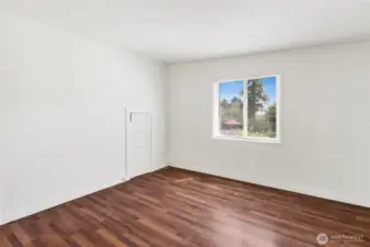 Second bedroom with closet and laminate wood flooring.