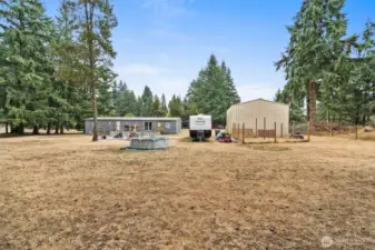 Back yard with dog kennel behind shop.
