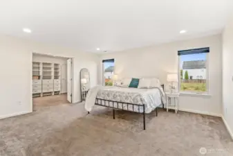 Vast primary bedroom with a view of the french door leading to the walk-in closet