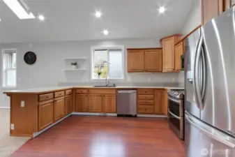 This spacious kitchen features ample counter space, warm wood cabinetry, and stainless steel appliances. The open layout and natural light make it perfect for cooking, entertaining, and gathering with loved ones.