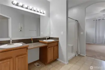 The primary bath features dual sinks, a spacious vanity, and a walk-in shower for added convenience. Thoughtfully designed to provide both function and comfort in your daily routine.
