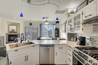 Quartz countertops, large sunken SS sink, pendant lighting, shaker cabinet doors with black handles
