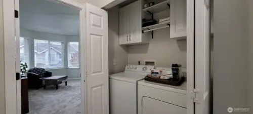 Laundry sits outside primary bedroom, has close hanging bar & new flooring