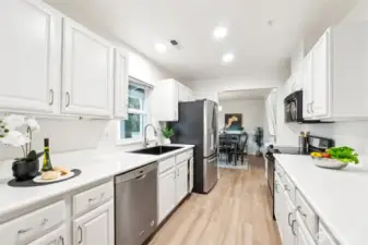Spacious kitchen features white newly painted cabinets, new sink, SS appliances