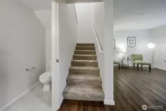 This photo shows the powder room to the left of the stairs & the sitting room to the right. The stairs lead up to the 2nd bedroom & loft area