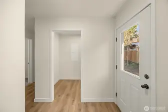 Rear entry to the right with spacious utility room straight ahead and bedrooms down the hall on the left