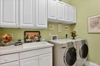 Your dream laundry room provides abundant storage, wash basin, folding counter, custom paint, Solar tube, and a fabulous set of Kenmore Elite front load washer and dryer.