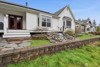 Flagstone leads you around the West side of the home lined with Peach Colored Rhododendrons.