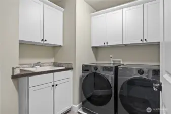 Upstairs laundry room, complete with sink and plenty of cabinets