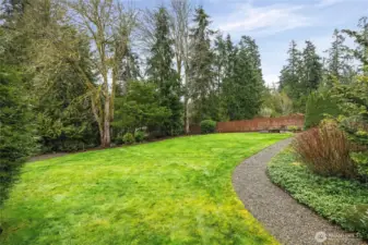 The yard is lined with mature landscaping, making it as beautiful as it is functional