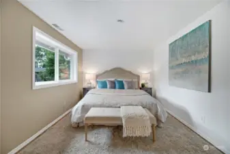 The Primary Suite exudes comfort and tranquility, featuring a large window that bathes the room in natural light and offers serene views. With its warm laminate hardwoods, and cozy ambiance, this bedroom is a perfect retreat for relaxation.