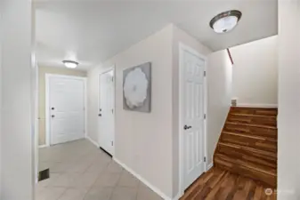 The foyer features ceramic tile floors and fresh paint, creating a bright and welcoming entrance. Conveniently located under the stairs, the powder room is accessible through the door to the left of the staircase.