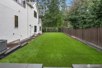 A Side Yard Customized with Turf Perfect for Soccer, Cornhole, or your Own Personal Favorite Summer Game.