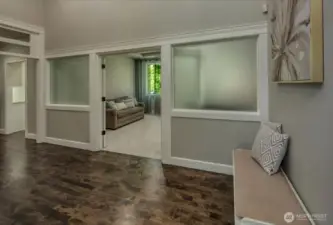 This cozy secondary living flex space features a classic gas fireplace framed by elegant columns, carpeting, and views to the expansive private back yard—ideal for relaxing, reading, or hosting intimate gatherings in comfort.