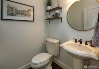 Stylish powder room features elegant pedestal sink, all new matte fixtures, floating wood shelves.