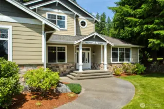 Front Entry features a wide stairway, charming covered porch, and detailed stonework.