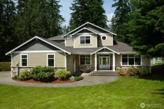 A wide stairway, charming covered porch, and detailed stonework that perfectly complements the natural surroundings.
