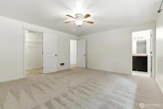 Primary bedroom looking at walk in closet, hall door and primary bath.