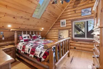 Upstairs primary bedroom, with large windows and a skylight for extra natural light.