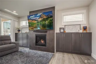Elegant gas fireplace with tiled surround and custom tall cabinetry on either side