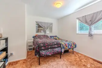 The first bedroom offers a comfortable amount of space, easily accommodating a king-size bed if you choose. With natural light from the window and a simple layout, it’s a flexible room that can adapt to your needs.