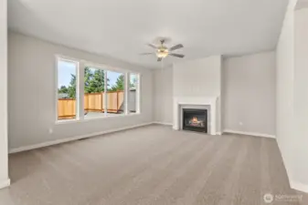 Large living room features a gas fireplace to stay warm on cooler evenings and a ceiling fan to stay comfortable throughout the year.