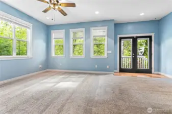 This space is massive. Enough room for a living space and sitting area. Those French doors lead to a small deck and full-fenced private patio with an exit to the driveway.