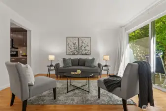 Sliding glass doors lead to an adorable patio, surrounded by lush greenery that makes it a perfect spot for relaxing or entertaining.